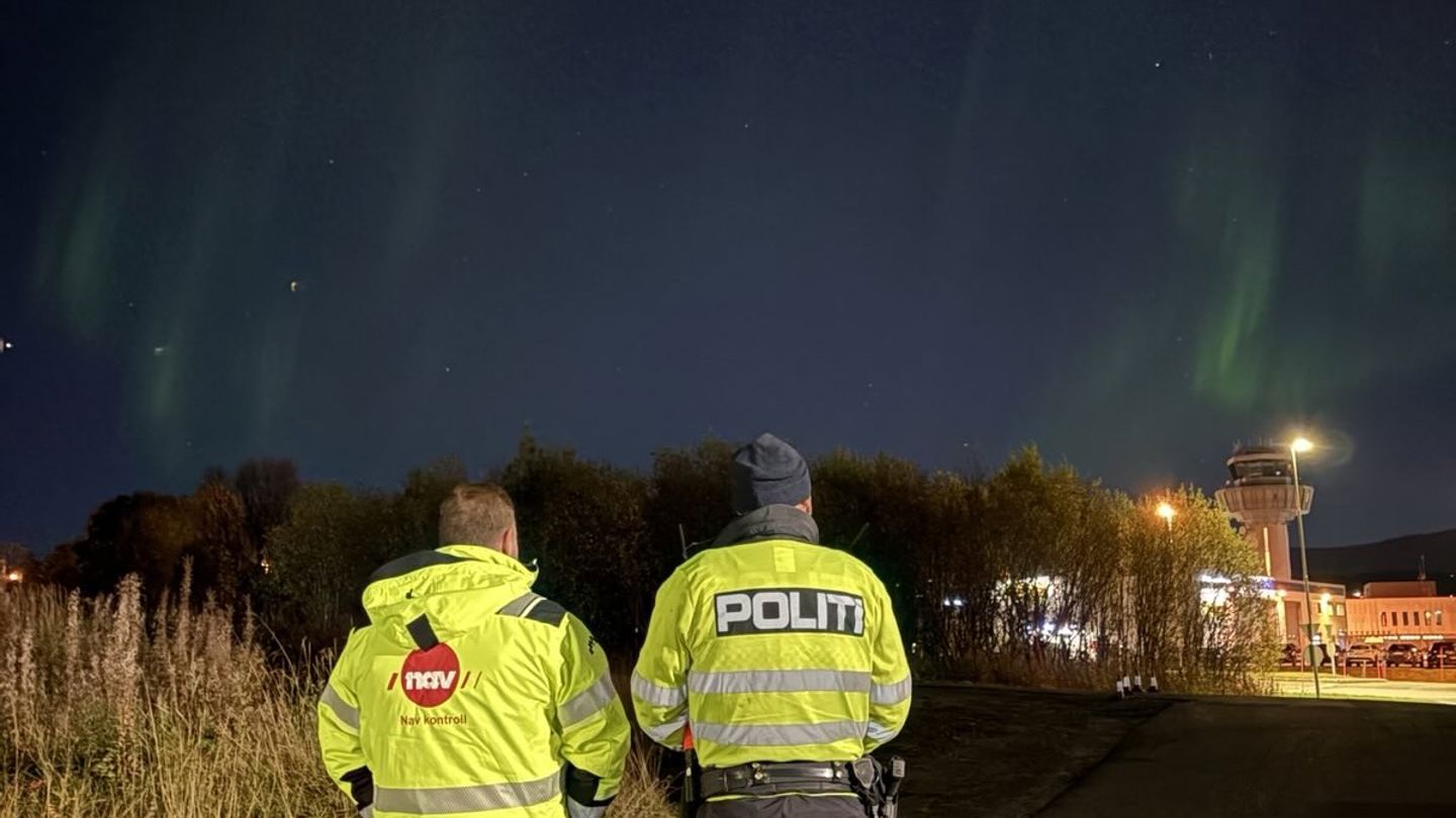 to personer med ryggen til ser på nordlyset