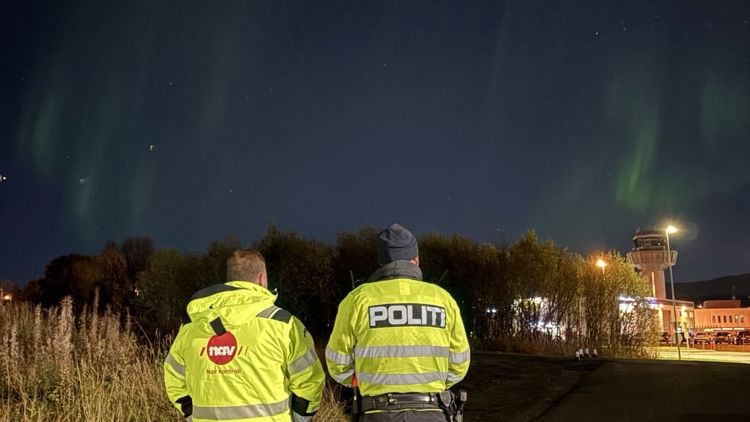 To personer med ryggen til ser på nordlyset
